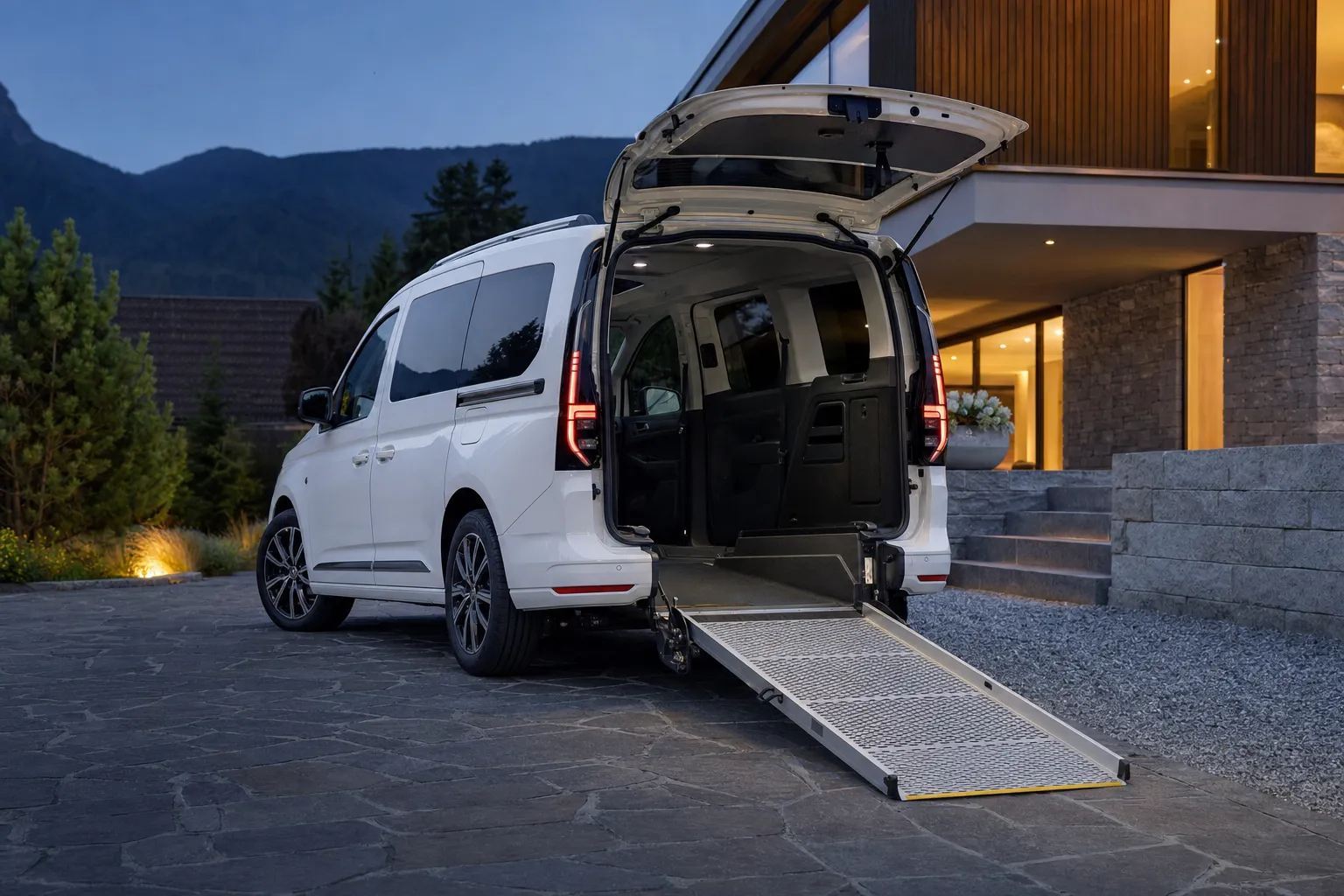 Weißer VW Caddy von Bayer Mobility mit ausgeklappter Rollstuhlrampe
